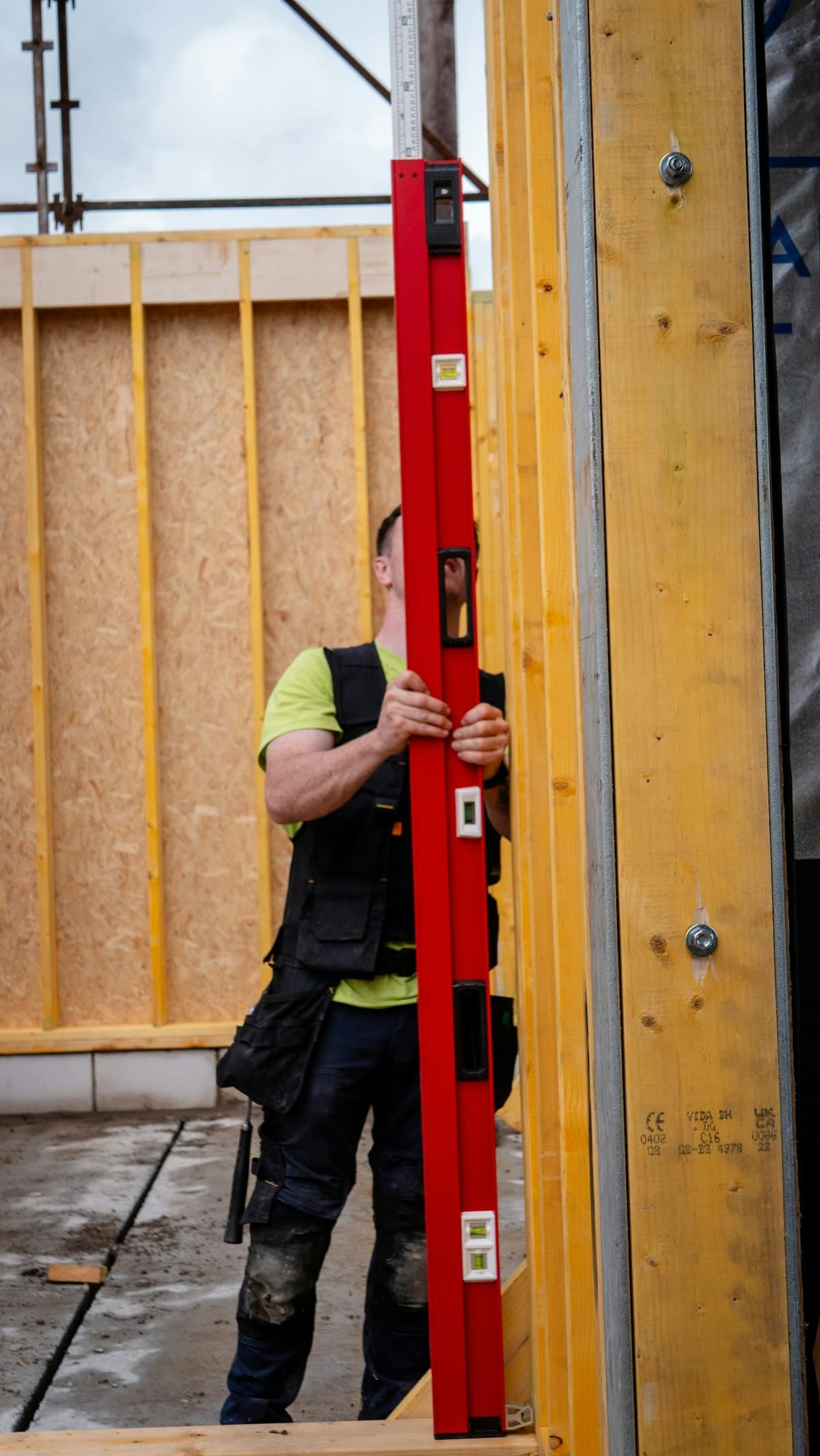 Carpenter checking framing with a level